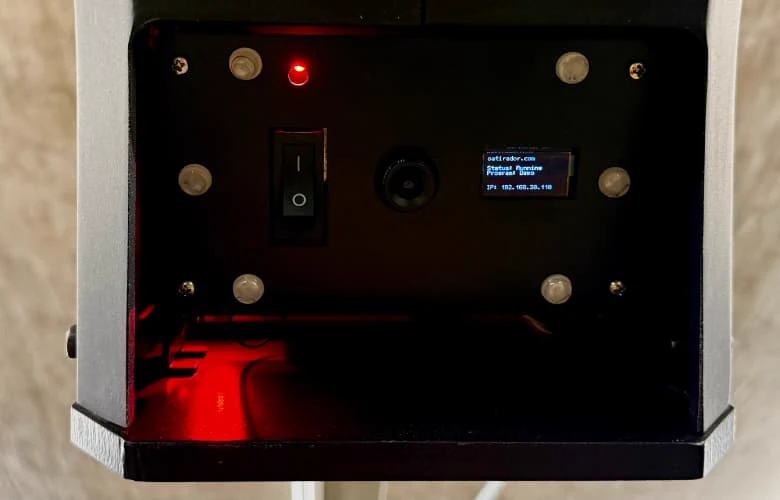 Compartimento inferior do TANK com câmera e display de status, iluminado em vermelho