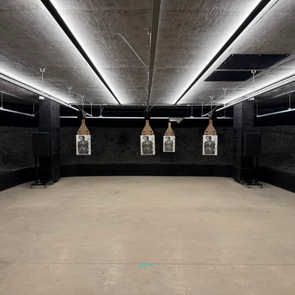 Raia de tiro indoor com quatro transportadores TANK no teto e alvos de papel, contenção de borracha ao fundo